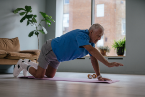 man practicing yoga indoors to relieve arthritis stiffness during winter.